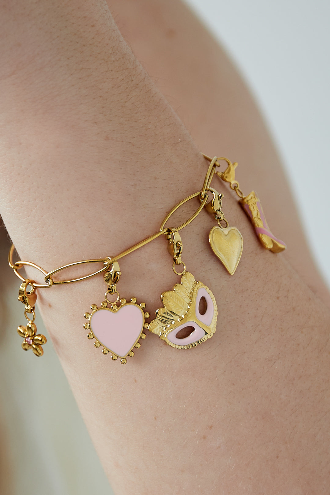 Gouden glamour bedelarmband met speelse roze details