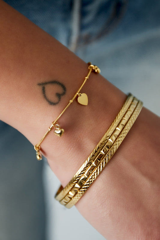 Gouden harten armband met delicate hangende bedeltjes