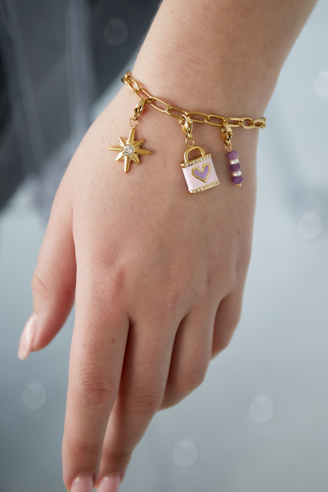 Lila liefdesarmband met pastel- en gouden bedels